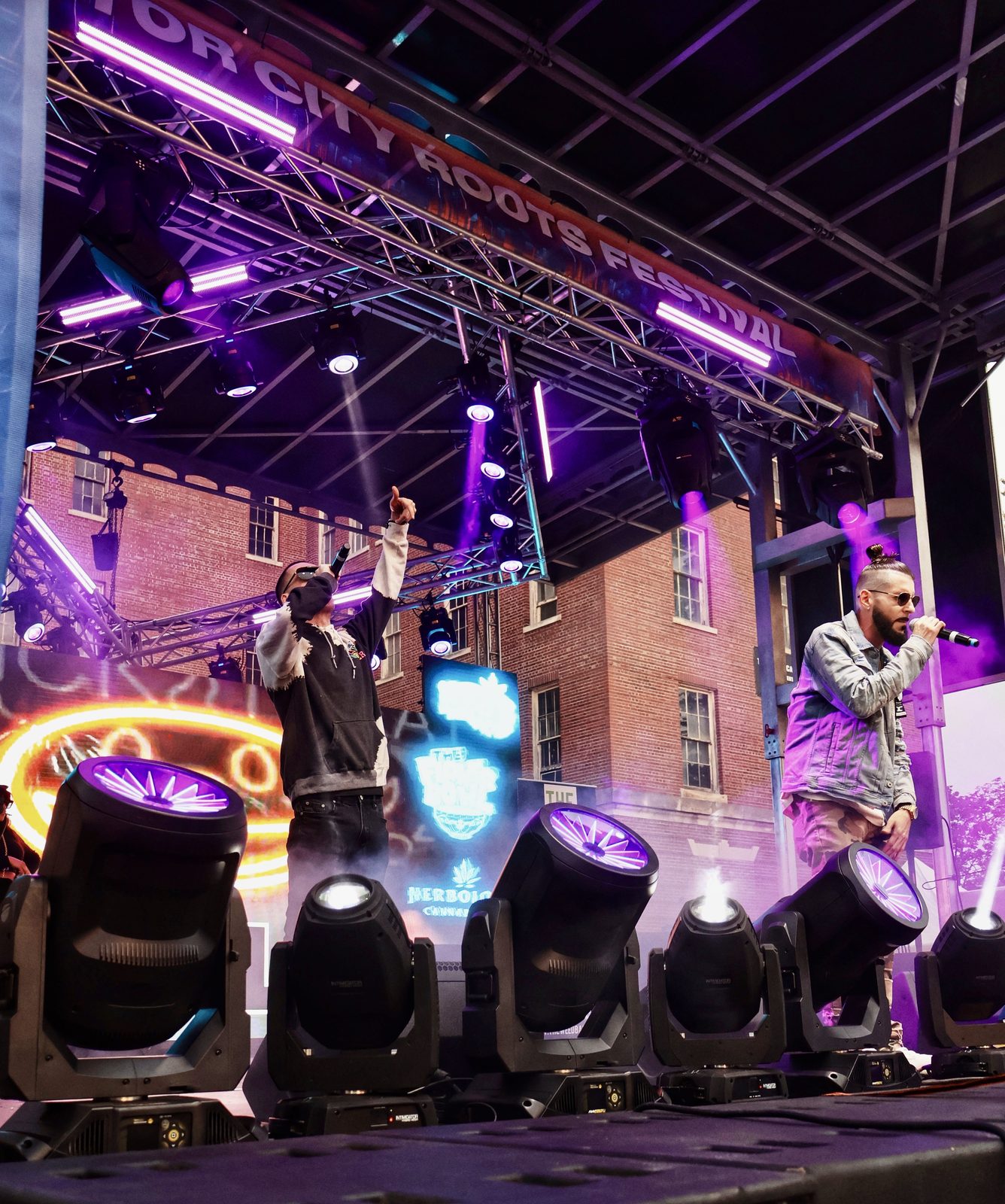 KING T and LUSS performing on a stage under purple lights