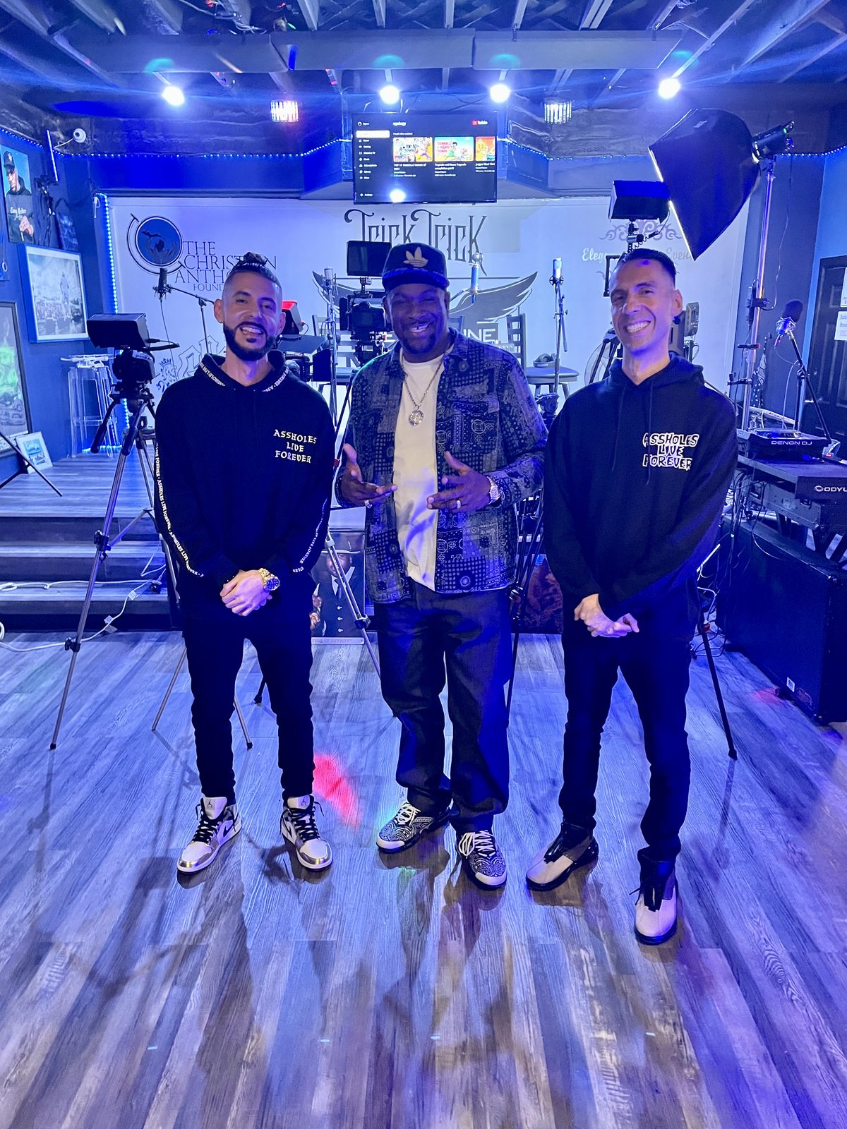 KING T and LUSS with Trick Trick on a stage lit in blue