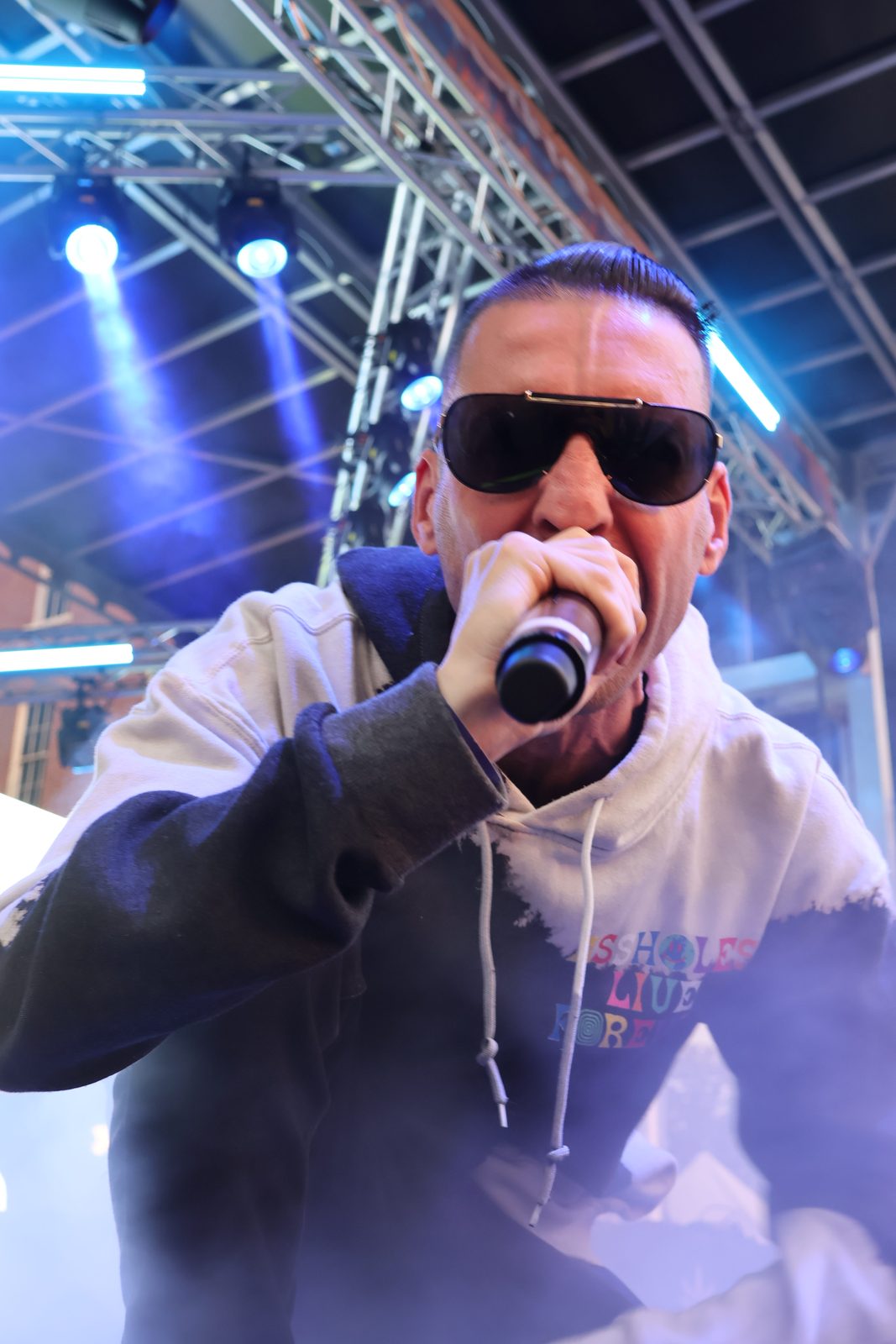 KING T performing with a mic under stage lights