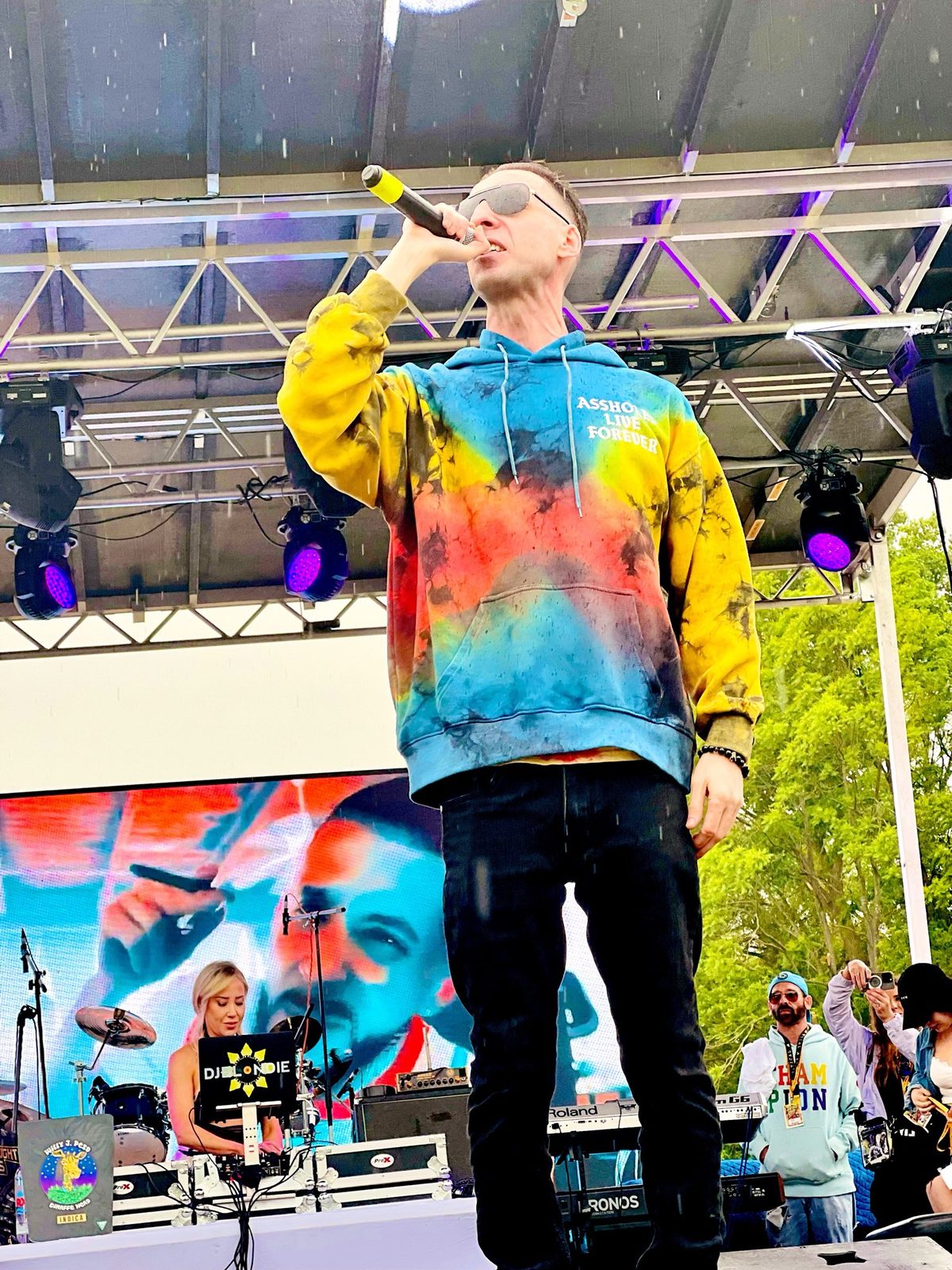 Performing on stage in a tie-dye hoodie