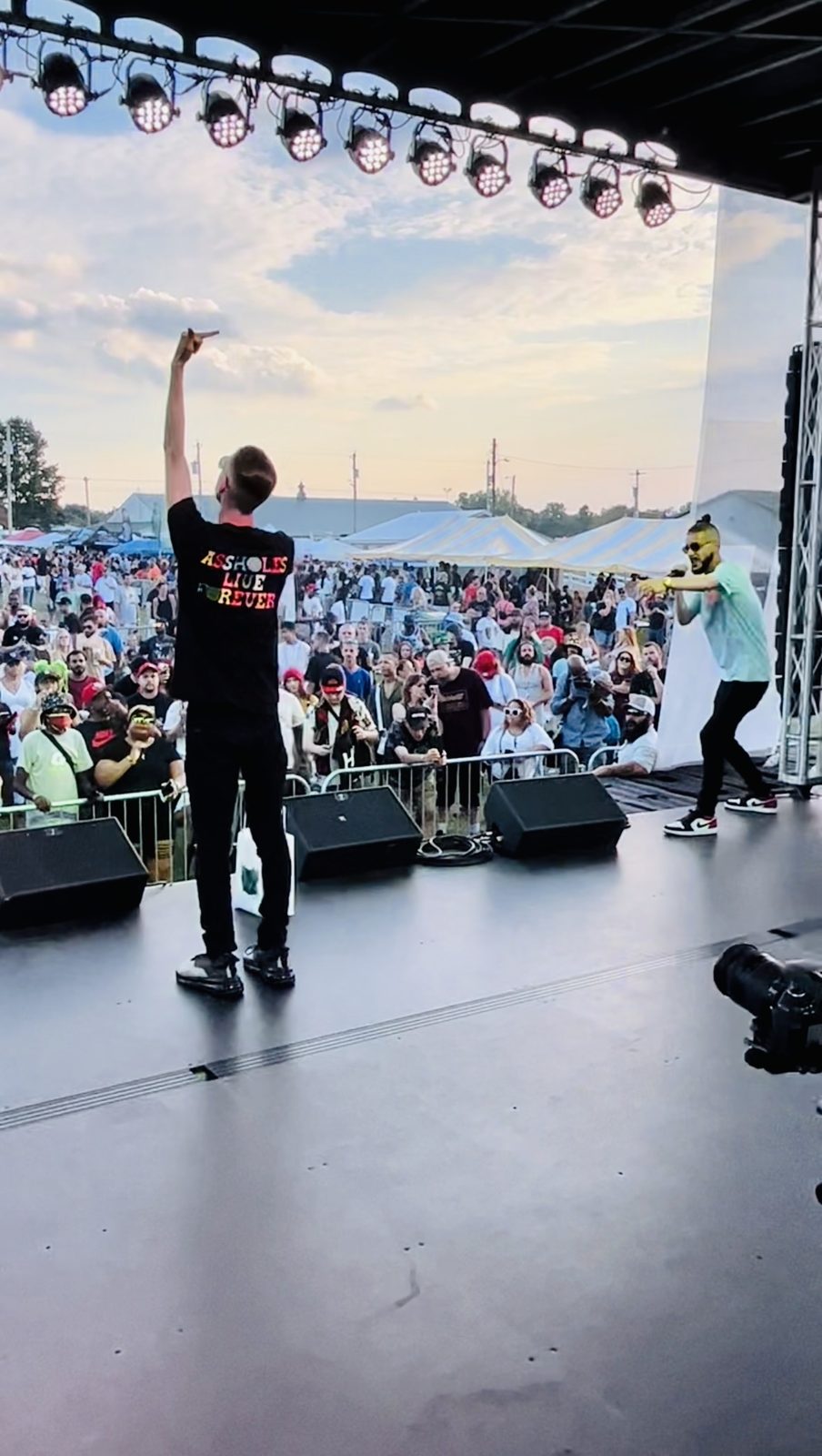 A TNL performer on stage against a sunset sky
